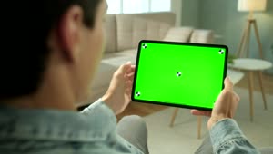 Stock Video Man Using Green Screen Tablet In Neutral Living Roo Animated Wallpaper
