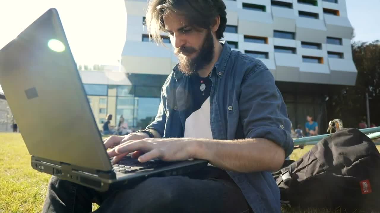 Download Stock Video Man Typing On Laptop Outside Smiles In Triump Animated Wallpaper