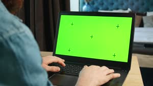 Stock Video Man Types On Greenscreen Laptop In Bedroo Animated Wallpaper