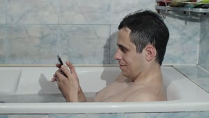 Stock Video Man Texting In The Bathtu Animated Wallpaper