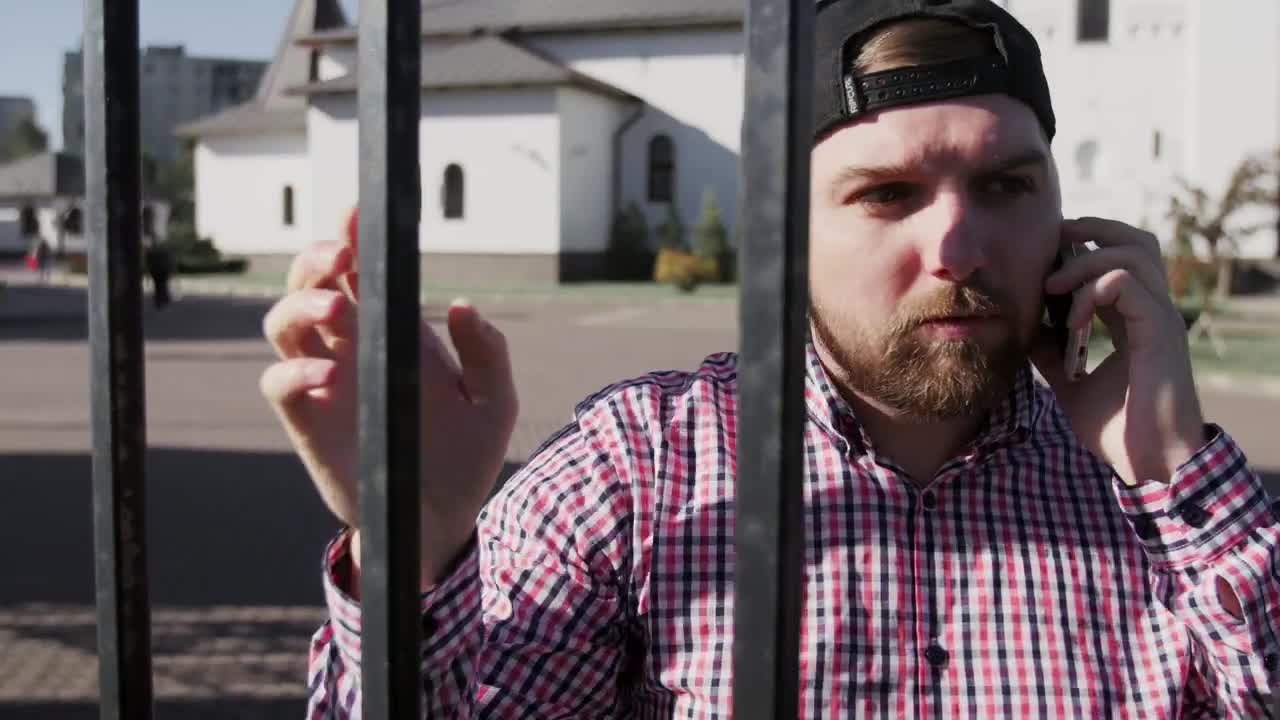 Download Stock Video Man Talking On The Phone By A Metal Gat Animated Wallpaper