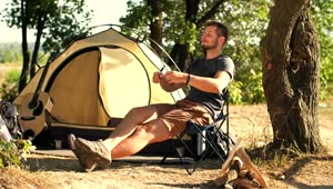 Stock Video Man Relaxing In His Camp In Natur Animated Wallpaper