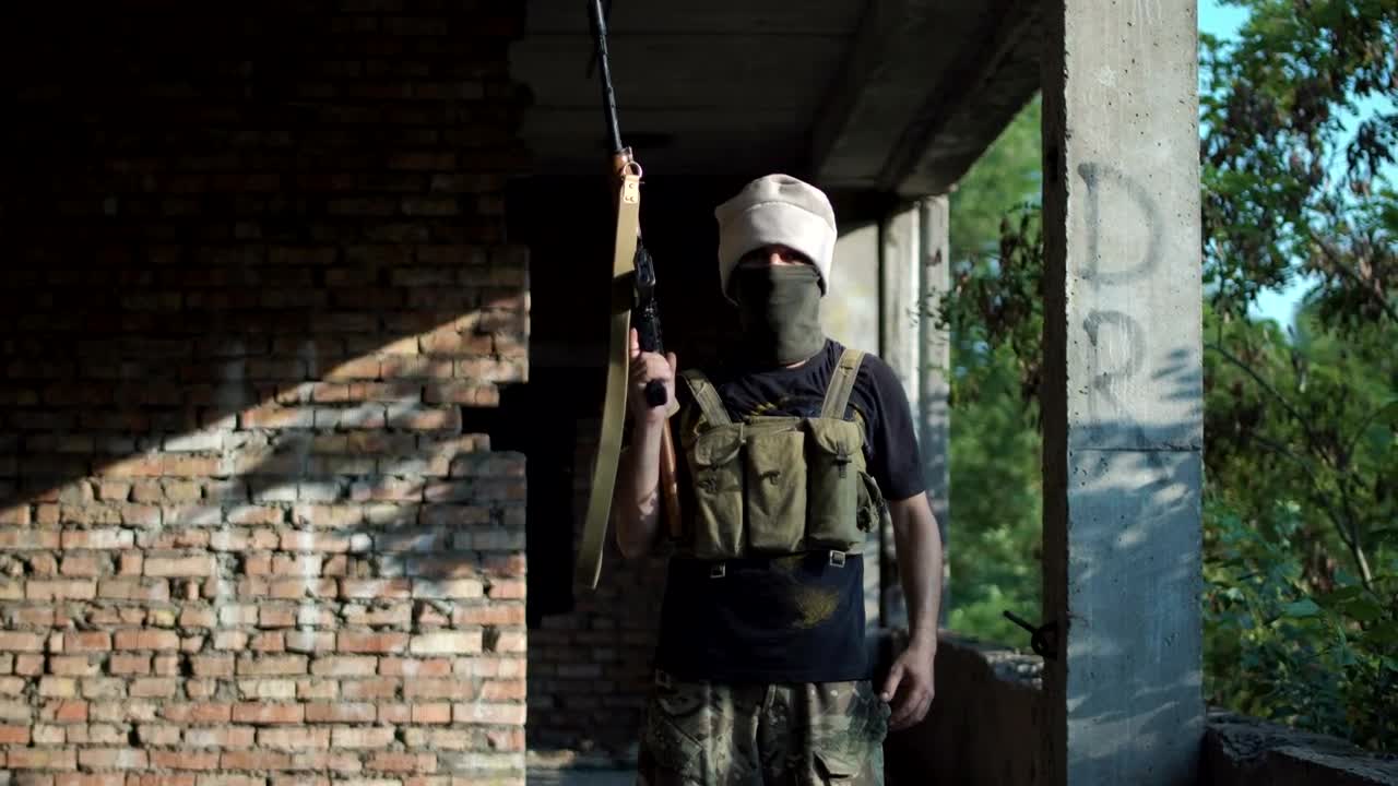 Download Stock Video Man Posing With A Gun On An Abandoned Sit Animated Wallpaper