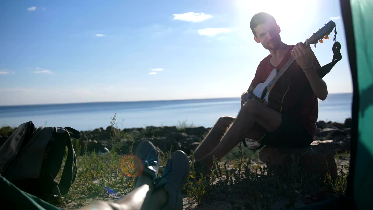 Download Stock Video Man Playing A Guitar While Campin Animated Wallpaper