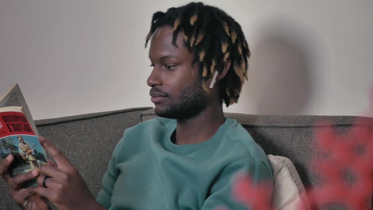 Download Stock Video Man On A Sofa Listening To Music And Reading Animated Wallpaper