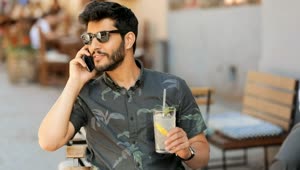 Stock Video Man In Sunglasses Talks On Mobile Holding Lemonad Animated Wallpaper