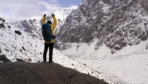 Stock Video Mountaineer Celebrating With Raised Arms In The Mountains Live Wallpaper