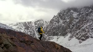 Stock Video Mountaineer Walking On A Cliff In A Winter Mountain Range Live Wallpaper