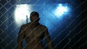 Download Stock Video Muscular Man Behind A Wire Fence Live Wallpaper