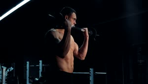 Stock Video Muscular Man Lifting A Barbell In A Dark Gym Live Wallpaper