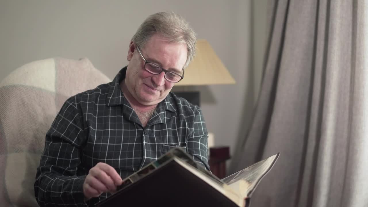 Download Stock Video Old Man Remembering With His Photo Album Live Wallpaper