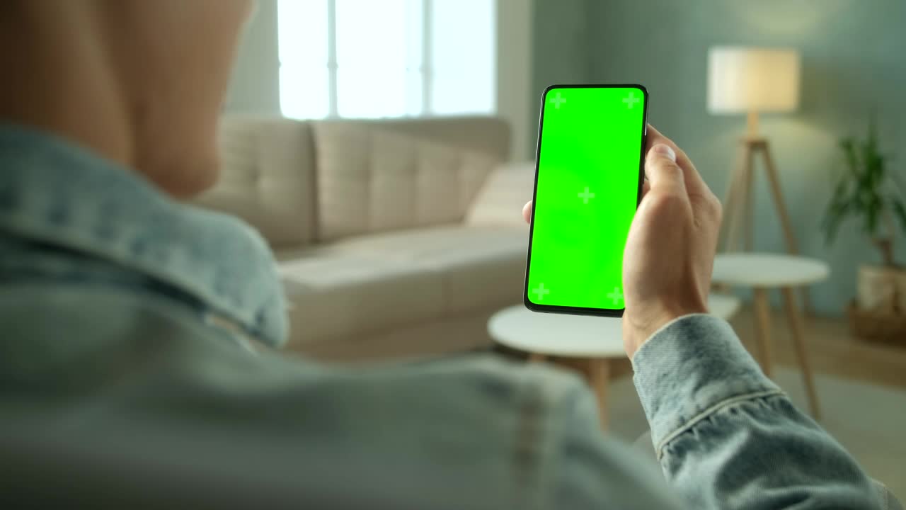 Download Stock Video Over Shoulder View Of A Man Holding A Green Screen Live Wallpaper