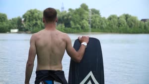 Stock Video Paddlesurfer Stands With Board Looking At Water Live Wallpaper