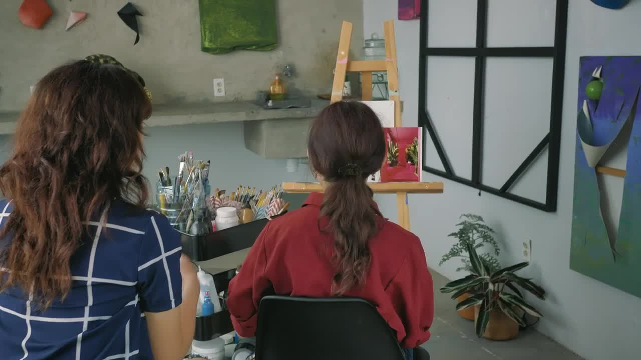 Download Stock Video Pair Of Artist Girls Working Together On A Painting Live Wallpaper