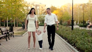 Stock Video Parents Walking With Their Little Son In The Park Live Wallpaper