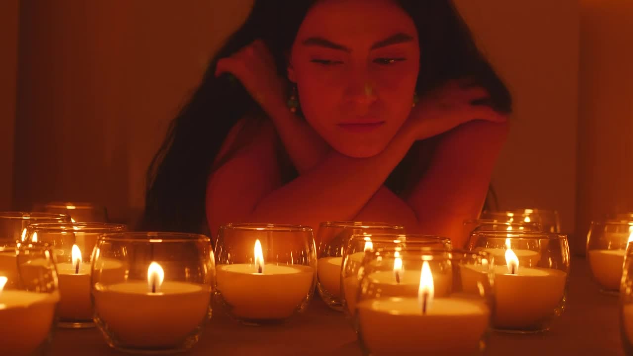 Download Stock Video Pensive Woman In The Dark Surrounded By Burning Candles Live Wallpaper