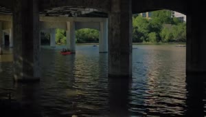 Stock Video People Rowing In A River Under A Large Bridge Live Wallpaper