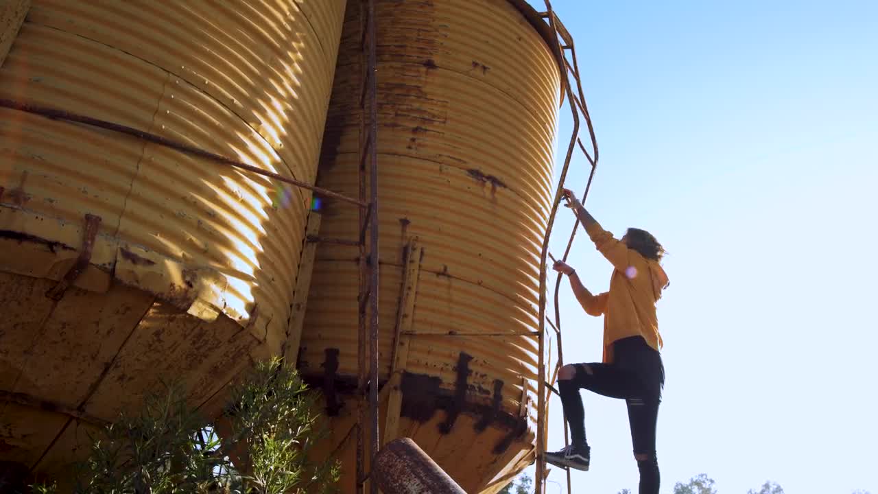 Download Stock Video Person Climbs Yellow Water Tower Live Wallpaper
