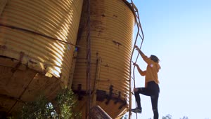 Stock Video Person Climbs Yellow Water Tower Live Wallpaper