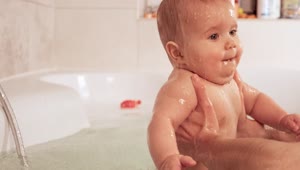 Stock Video Person Holding Baby In Bathtub With Both Hands Live Wallpaper