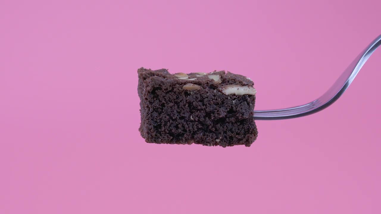 Download Video Stock Piece Of Brownie On A Fork On A Pink Background Live Wallpaper Free