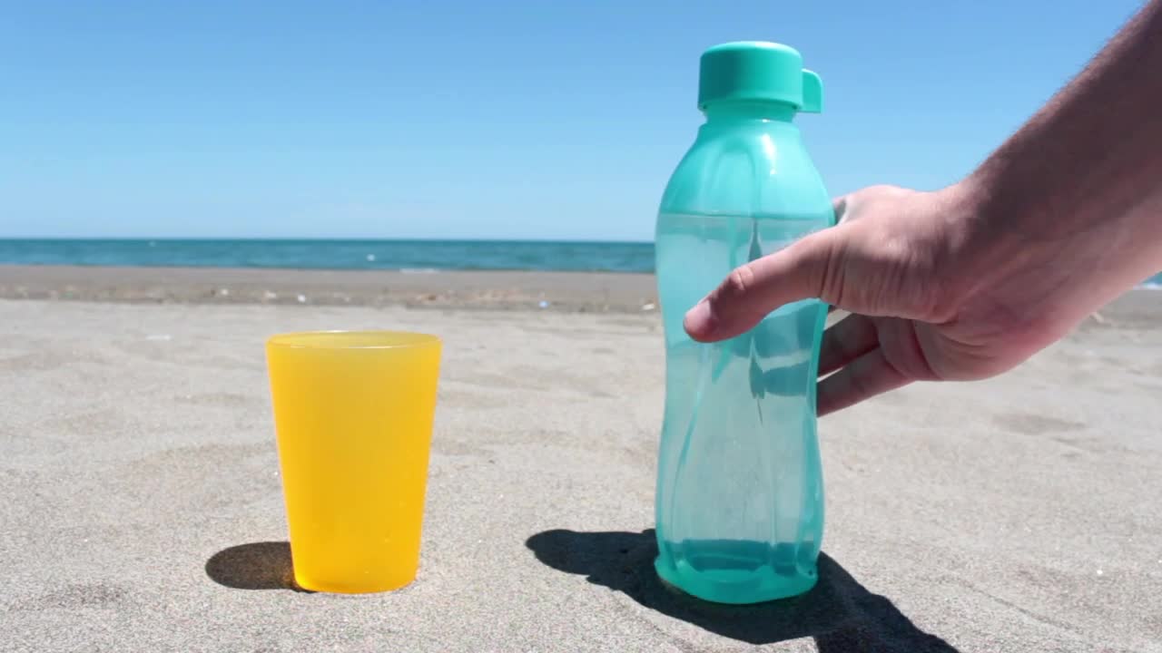 Download Video Stock Pouring Water In A Glass On A Sunny Beach Live Wallpaper Free