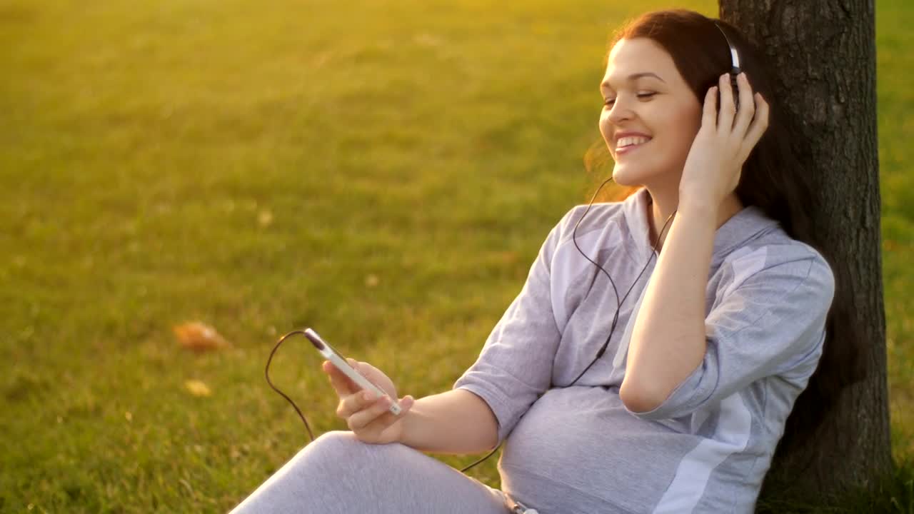Download Video Stock Pregnant Woman Listening To Music On Her Cell Phone Live Wallpaper Free