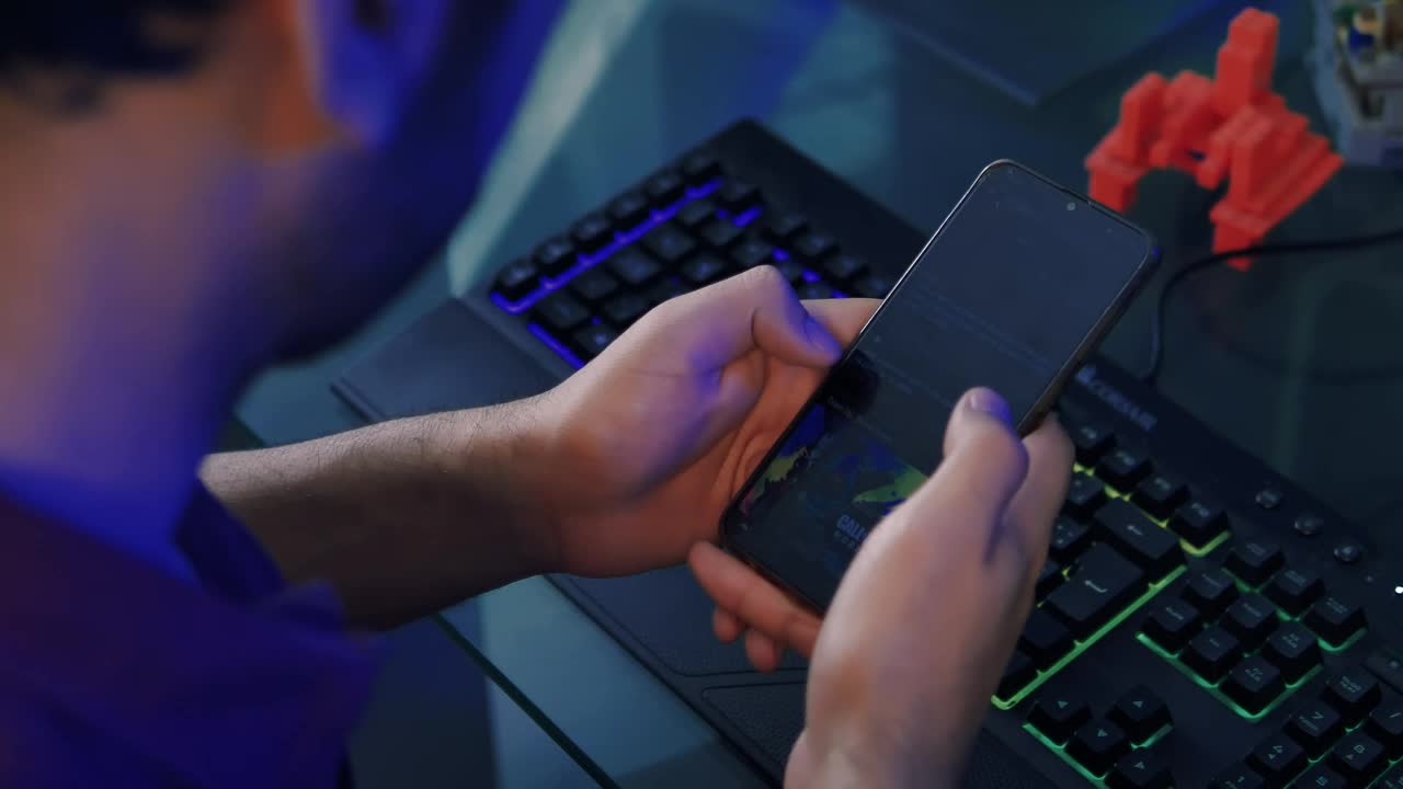 Download Video Stock Programmer Using His Cell Phone While Working At His Desk Live Wallpaper Free