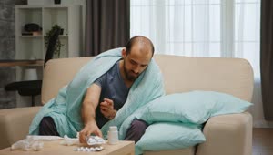 Video Stock Quarantined Sick Man Sits On Sofa Holding Medication Live Wallpaper Free