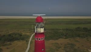 Video Stock Red Lighthouse Near The Shore Spinning Aerial Shot Live Wallpaper Free