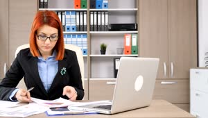 Download Free Stock Video Redhead Woman Working At Her Desk Live Wallpaper