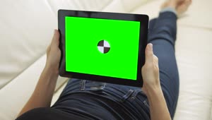 Free Stock Video Relaxing On Sofa Holding Greenscreen Tablet With Chroma Key Live Wallpaper