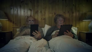 Free Stock Video Senior Couple Reading On The Bed With Devices Live Wallpaper