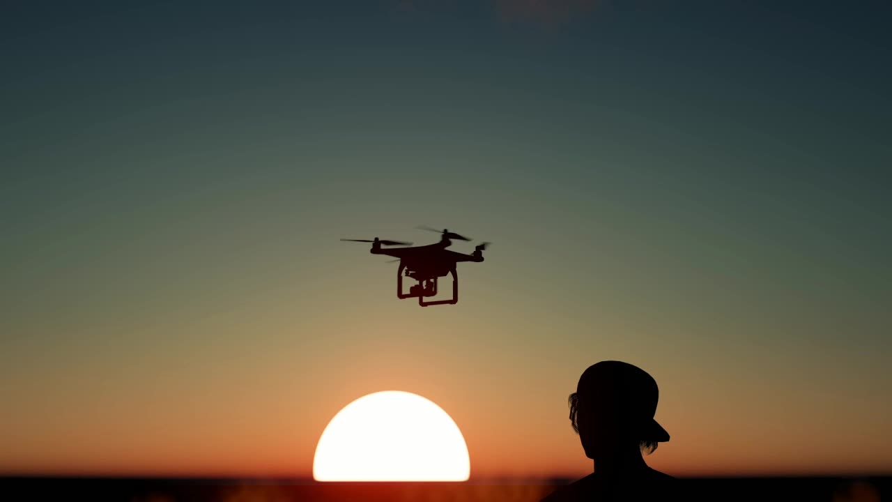 Download Free Stock Video Silhouette Of A Boy Flying A Drone At Sunset Live Wallpaper