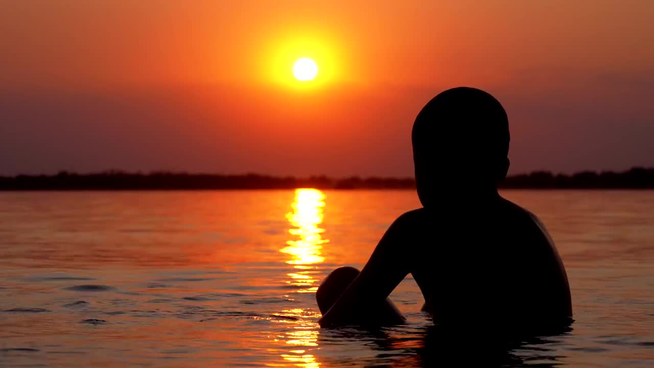 Download Free Stock Video Silhouette Of A Boy In The Sea At Sunset Live Wallpaper