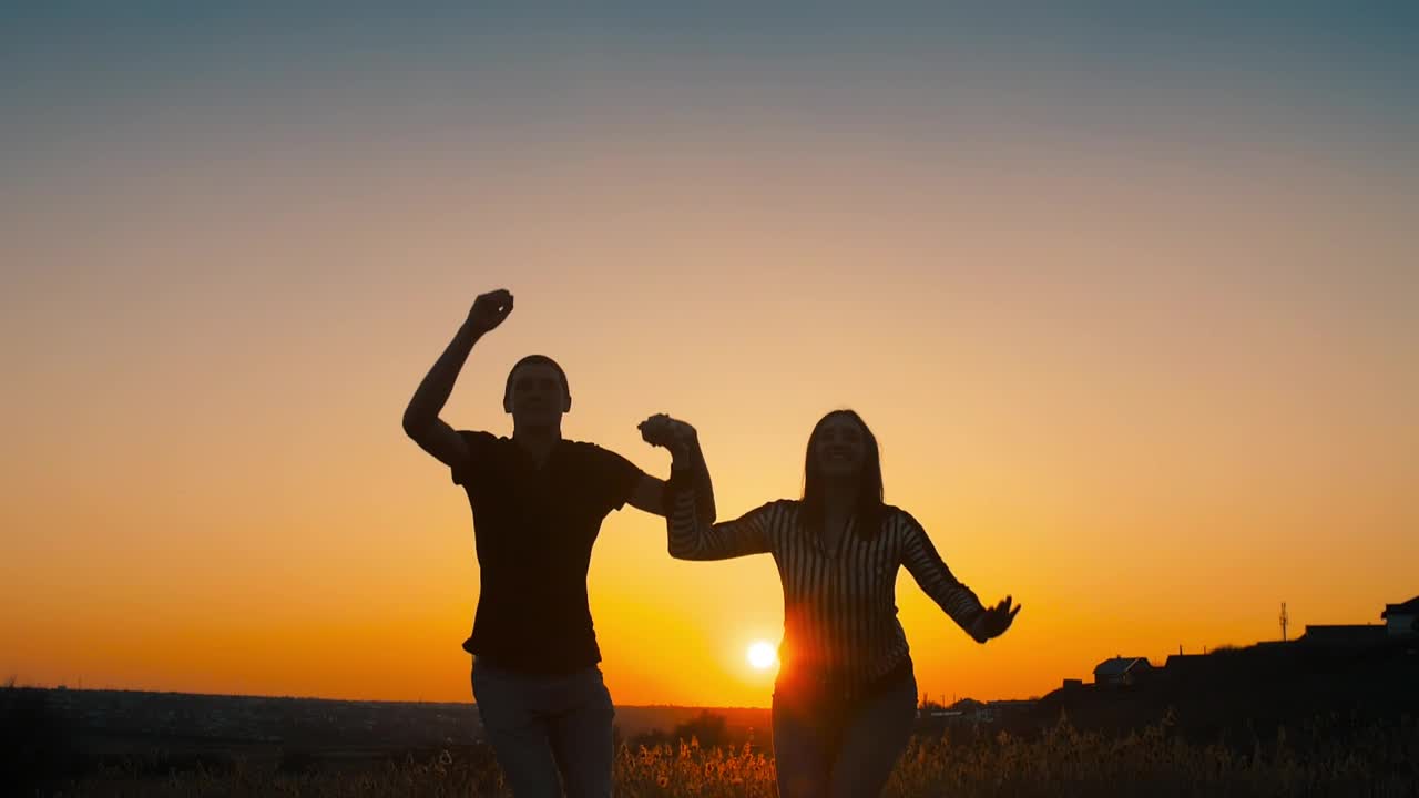 Download Free Stock Video Silhouette Of A Couple Jumping In The Sunset Live Wallpaper
