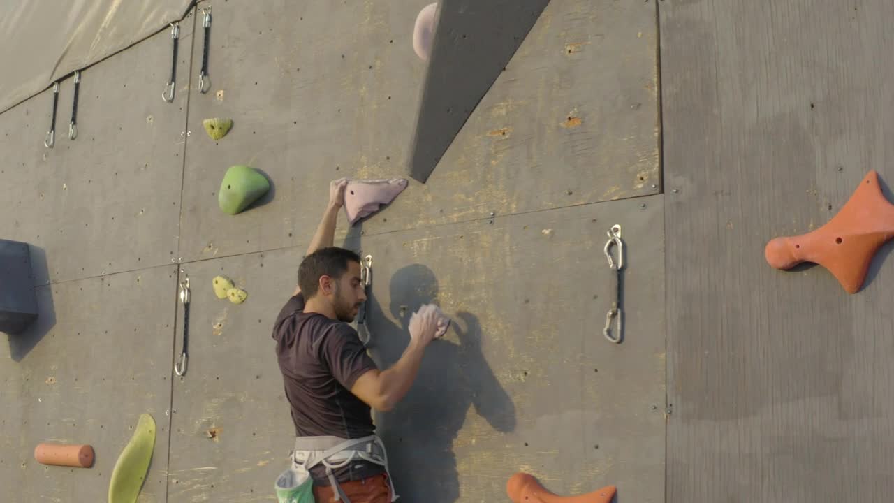 Download Free Video Stock Skillfully Climbing To The Top Of A Large Mountaineering Wall  LargeLive Wallpaper