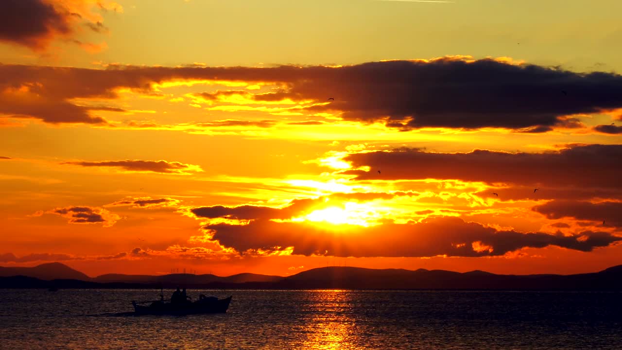 Download Free Video Stock Small Fishing Boat Crossing The Sunset Live Wallpaper