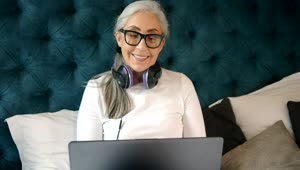 Free Video Stock Smiling Elderly Woman On Laptop In Bed Live Wallpaper