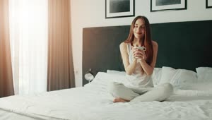 Free Video Stock Smiling Woman Enjoying Morning Coffee In Bed Live Wallpaper