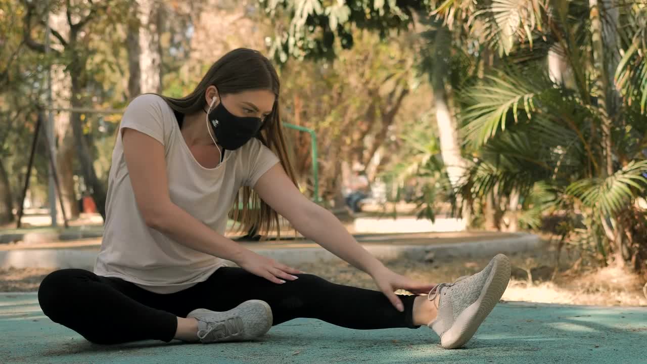 Download Free Video Stock Sportswoman Stretching With A Face Mask Live Wallpaper