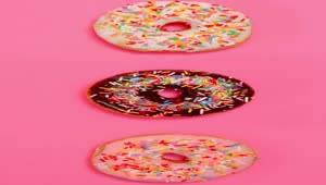 Free Video Stock taking three glazed donuts in a row on a pink Live Wallpaper