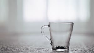 Free Video Stock teapot pouring tea into clear glass grabbed by hand Live Wallpaper