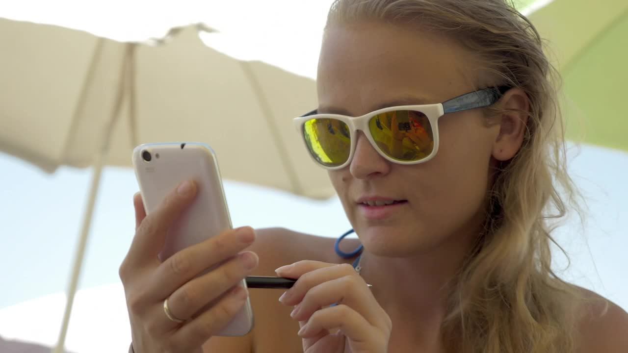 Download Free Video Stock texting while relaxing on the beach Live Wallpaper