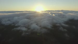 Free Video Stock the sun setting on the horizon of a cloudy mountain Live Wallpaper