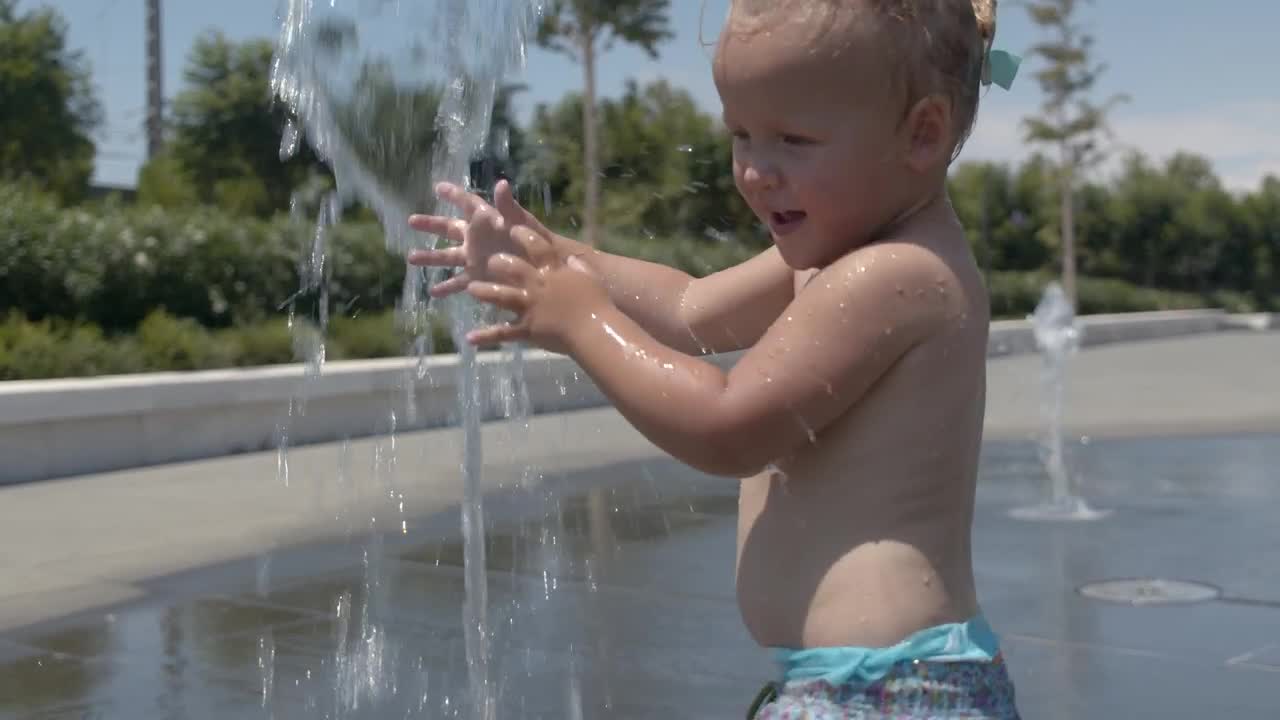 Download Free Video Stock toddler playing in a water fountain Live Wallpaper