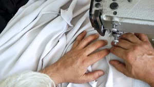 Free Video Stock top view of a tailors hand sewing a shirt Live Wallpaper