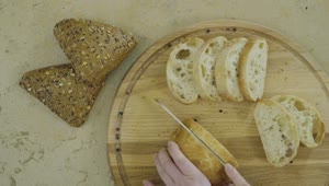 Free Video Stock top view of hands cutting fresh bread on wood board Live Wallpaper