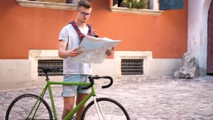 Free Video Stock tourist on bicycle checks map in european town Live Wallpaper