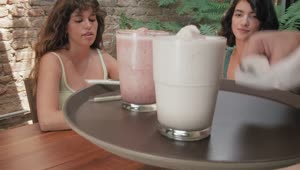 Free Stock Video Waiter Serving A Couple Of Milkshakes To Two Girls Live Wallpaper